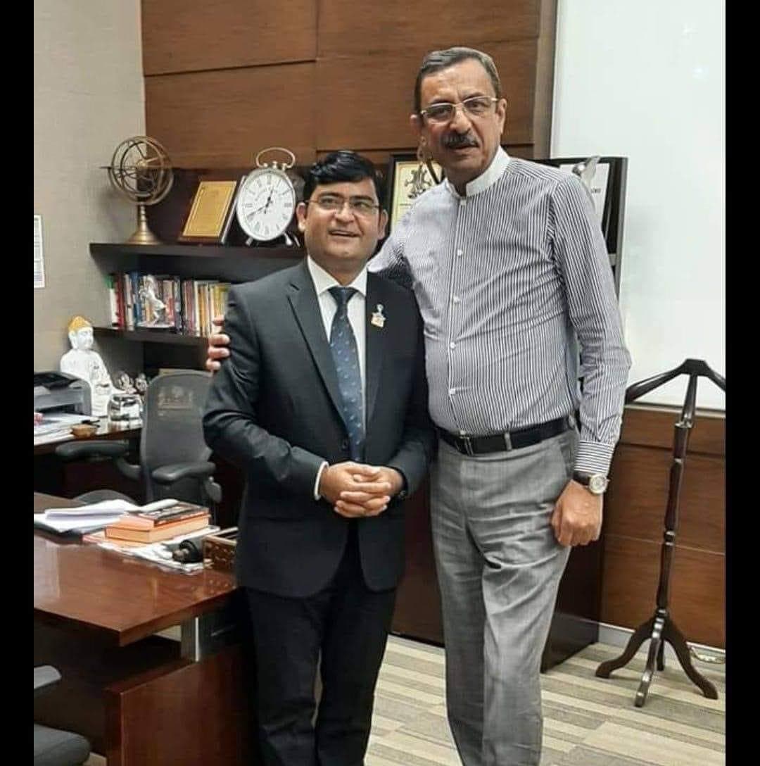 Aadesh Sharma standing with a senior professional in an office