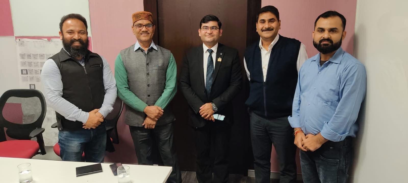 Aadesh Sharma standing with four colleagues in a meeting room