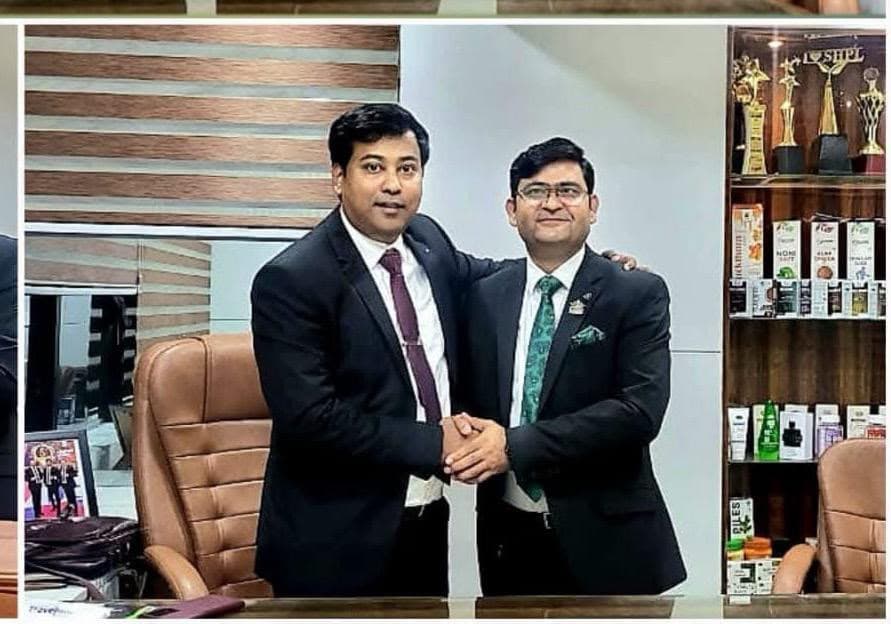 Aadesh Sharma shaking hands with a business associate in an office